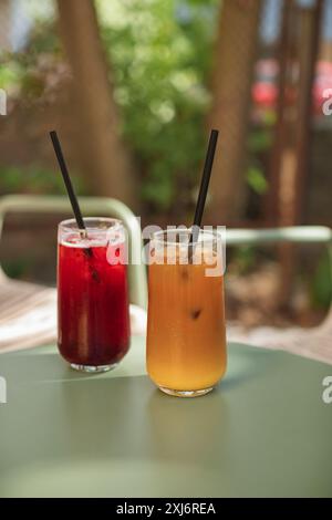 Primo piano di un caffè ghiacciato e di una bevanda alla limonata di frutta su un tavolo da caffè all'aperto in estate Foto Stock