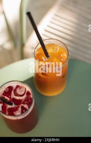 Primo piano di un caffè ghiacciato e di una bevanda alla limonata di frutta su un tavolo da caffè all'aperto in estate Foto Stock