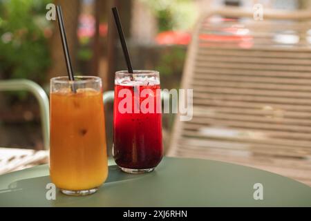Primo piano di un caffè ghiacciato e di una bevanda alla limonata di frutta su un tavolo da caffè all'aperto in estate Foto Stock