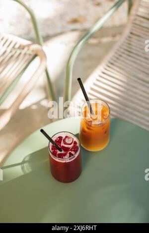 Vista dall'alto di un caffè ghiacciato e di una bevanda alla limonata di frutta su un tavolo da caffè all'aperto in estate Foto Stock
