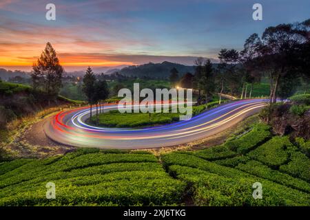 Sentieri leggeri su una tortuosa strada di montagna al tramonto, Giava Occidentale, Indonesia Foto Stock