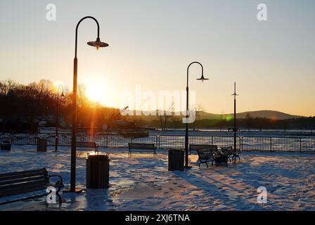 Il sole tramonta su un parco in inverno Foto Stock