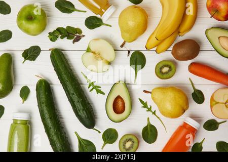 Lay piatto con colorate di frutta e verdura fresche e di bottiglie con i frullati su sfondo di legno Foto Stock