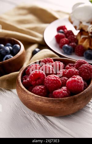 ciotole con frutti di bosco e waffle belgi sfocati sullo sfondo Foto Stock