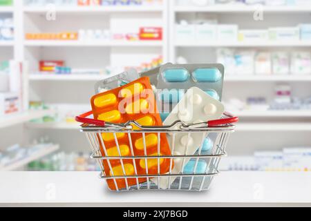 Pacchetto di pillole mediche nel carrello della spesa con gli scaffali della farmacia sfocati sullo sfondo Foto Stock