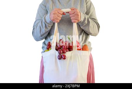 La donna tiene una borsa della spesa riutilizzabile ecologica piena di frutta e verdura fresca, isolata su sfondo bianco con ritaglio Foto Stock