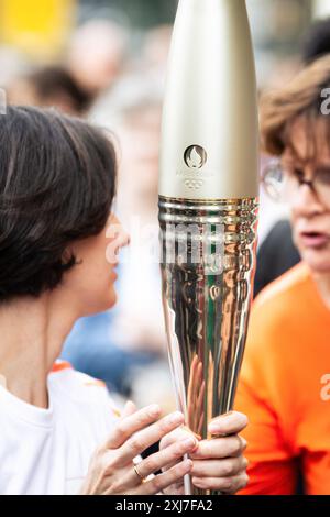 Parigi, Francia. 15 luglio 2024. Un portabicchieri olimpico tiene una torcia olimpica a Place Bastille. Migliaia di persone hanno riempito le strade di Parigi per guardare la torcia olimpica passare il suo secondo giorno nella capitale francese. Dopo un primo giorno emozionante, che coincise con le festività della Bastiglia, la torcia olimpica viaggiò di nuovo attraverso Place de Bastille verso Place de Republique, la sua destinazione finale. Credito: SOPA Images Limited/Alamy Live News Foto Stock