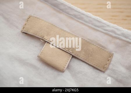 etichetta di abbigliamento vuota sullo sfondo della trama del tessuto Foto Stock