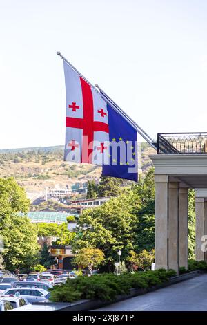 Tbilisi, Georgia - 24 GIUGNO 2024: Bandiere dell'Unione europea e della Georgia appese su un balcone a Tbilisi, Georgia. Foto Stock