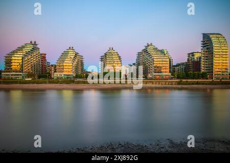 Lunga esposizione, appartamenti contemporanei in riva al fiume, Battersea Reach, al tramonto a Londra Foto Stock