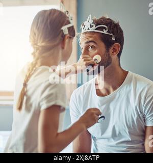 Corona, trucco e ragazza con papà in casa per vestirsi con una festa per il tè per legarsi insieme. Felice, cosmetico e bambino che si diverte con il padre per la fantasia Foto Stock
