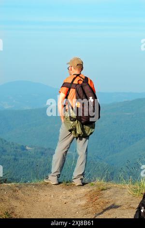 Escursione con vista posteriore con zaino in cima alla collina di Ostrvica che guarda in basso, Sumadija, Serbia centrale Foto Stock