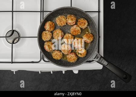 Vista dall'alto delle polpette di cottura in padella con olio d'oliva su un piano cottura a gas Foto Stock