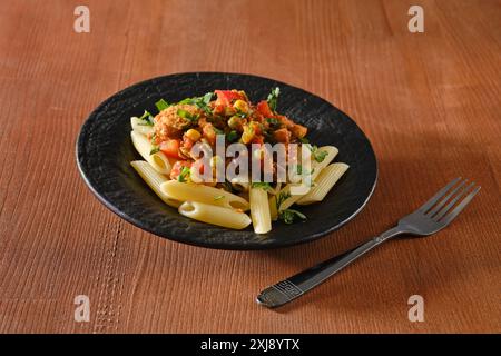 Fette di manzo fritte con verdure e salsa piccante con pasta su fondo in legno Foto Stock