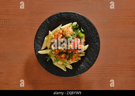 Vista dall'alto del piatto con fette di manzo fritte con verdure e salsa piccante con pasta Foto Stock