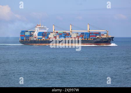 Città del Capo, Sud Africa. 16 luglio 2024: La nave portacontainer KOTA SINGA è una rotta marittima regolare tra l'Asia e la costa dell'Atlantico occidentale africana. La grande nave sta attualmente passando per il Capo di buona speranza. La situazione geopolitica nel Mar Rosso, segnata dagli attacchi degli Houthi alle navi mercantili nello stretto di Bab al-Mandab, ha portato a un'interruzione del traffico marittimo internazionale (parzialmente deviato verso il Corno d'Africa) e a un aumento delle tariffe merci tra Asia ed Europa/Maghreb. I media marocchini riferiscono che i prezzi di spedizione sono aumentati del 160-290% rispetto all'anno precedente. Crediti: Kevin Izorce/Alamy Live News Foto Stock