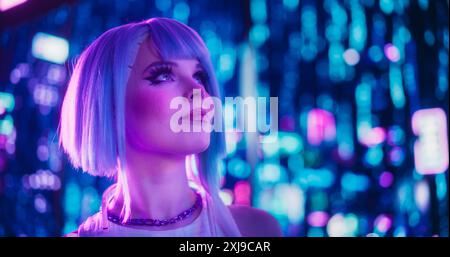 Ritratto cinematografico di un elegante modello Young Cosplay con capelli blu che girovagano per una futuristica Cybernetic City con luci al neon. Giovane donna eccitata in una realtà aumentata Cyberpunk Foto Stock