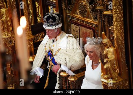 Re Carlo III, indossando la Corona Imperiale e la veste di Stato, legge il discorso del re, accanto alla regina Camilla, indossando il Diadem di Stato di Giorgio IV e la veste di Stato, durante l'apertura di Stato del Parlamento nella camera della camera dei Lord al Palazzo di Westminster, Londra. Data foto: Mercoledì 17 luglio 2024. Foto Stock