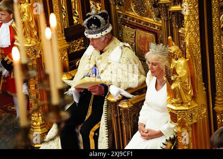 Re Carlo III, indossando la Corona Imperiale e la veste di Stato, legge il discorso del re, accanto alla regina Camilla, indossando il Diadem di Stato di Giorgio IV e la veste di Stato, durante l'apertura di Stato del Parlamento nella camera della camera dei Lord al Palazzo di Westminster, Londra. Data foto: Mercoledì 17 luglio 2024. Foto Stock