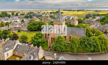 Dornoch Sutherland Scotland la cattedrale è circondata da alberi in estate e offre una vista sui campi lontani e sul mare Foto Stock