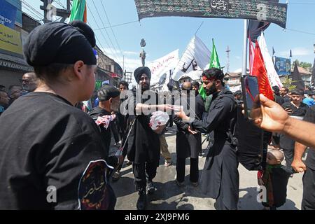 Srinagar, Jammu e Kashmir, India. 17 luglio 2024. I ragazzi sikh distribuiscono acqua tra i piangenti sciiti il decimo giorno di Ashura nel mese islamico di Muharram, a Srinagar (Credit Image: © Basit Zargar/ZUMA Press Wire) SOLO PER USO EDITORIALE! Non per USO commerciale! Foto Stock