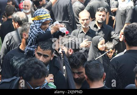 Srinagar, Jammu e Kashmir, India. 17 luglio 2024. Un ragazzo spruzza acqua tra gli sciiti in lutto il decimo giorno di Ashura nel mese islamico di Muharram, a Srinagar (Credit Image: © Basit Zargar/ZUMA Press Wire) SOLO USO EDITORIALE! Non per USO commerciale! Foto Stock