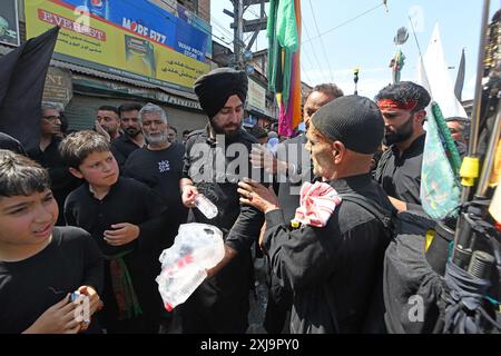 Srinagar, Jammu e Kashmir, India. 17 luglio 2024. I ragazzi sikh distribuiscono acqua tra i piangenti sciiti il decimo giorno di Ashura nel mese islamico di Muharram, a Srinagar (Credit Image: © Basit Zargar/ZUMA Press Wire) SOLO PER USO EDITORIALE! Non per USO commerciale! Foto Stock