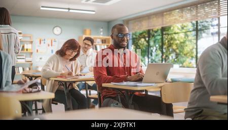 Gruppo eterogeneo di giovani e anziani multietnici seduti in un auditorium, che partecipa a una lezione di istruzione secondaria per migliorare l'esperienza professionale. Studenti maturi che si preparano per gli esami Foto Stock