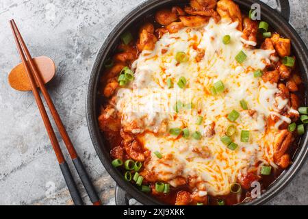 Il Buldak Fire Chicken coreano, composto da pollo piccante saltato in padella, è stato marinato in una varietà di spezie coreane ricoperte di mozzarella Foto Stock