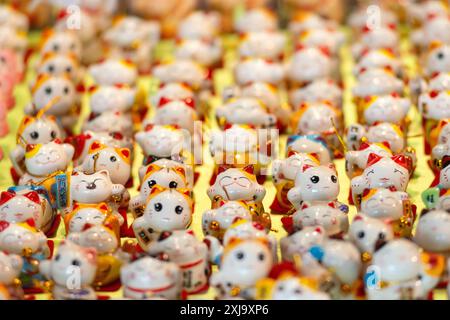 Statue tradizionali del gatto ondeggiante, conosciute anche come Maneki-neko Foto Stock