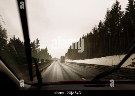 La prospettiva del conducente attraverso il parabrezza dell'autostrada invernale con semi-camion. Foto Stock