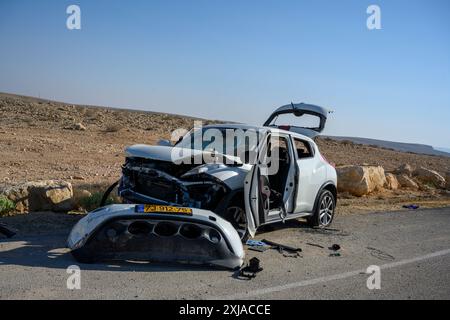 L'auto abbandonata ha tolto la maggior parte delle parti dopo essere stata lasciata sul lato della strada dopo un incidente. Fotografato nel deserto del Negev in Israele Foto Stock