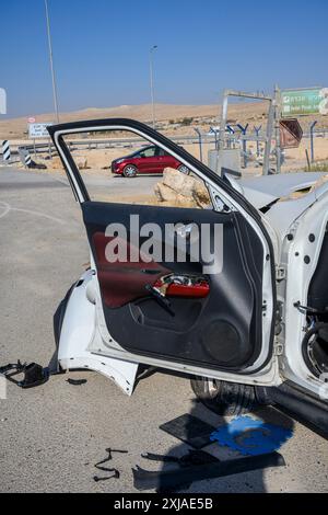 L'auto abbandonata ha tolto la maggior parte delle parti dopo essere stata lasciata sul lato della strada dopo un incidente. Fotografato nel deserto del Negev in Israele Foto Stock