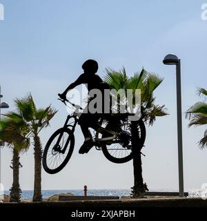 Un ragazzo che esegue una acrobazia con una bicicletta in uno skate Park a Tel Aviv, Israele Foto Stock