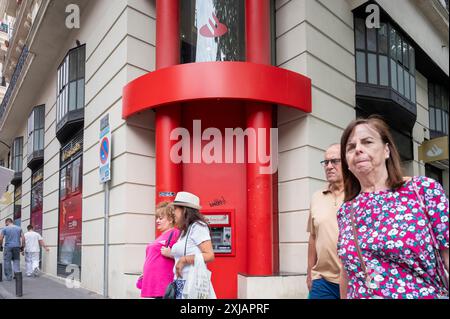 I pedoni passano davanti alla banca commerciale multinazionale spagnola e ai servizi finanziari, Santander Bank, in Spagna. Foto Stock