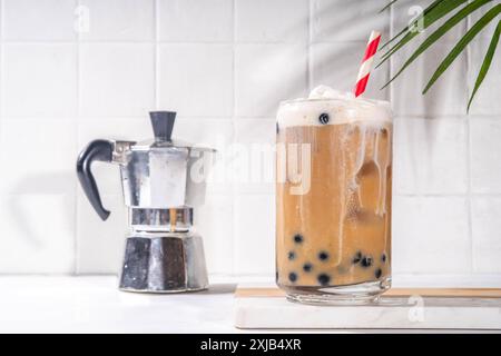 Classico boba bobble tea con perle di tapioca e crema non casearia montata sopra il bicchiere, dolce dolce dolce estivo su sfondo bianco della tavola c Foto Stock