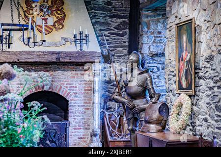 Waimes, Belgio. 2 giugno 2024. Sala principale del Castello di Reinhardstein, camino in mattoni e muri in pietra, vari oggetti d'epoca, meta medievale completa Foto Stock