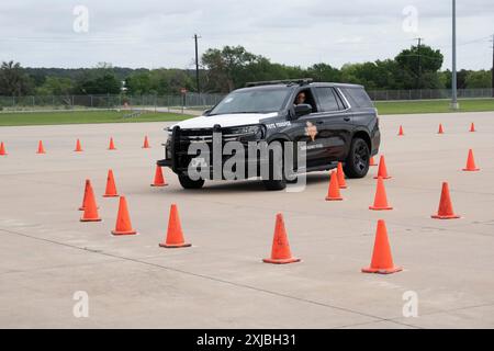 Florence Texas USA, 23 aprile 2024: Il trooper statale del Dipartimento della pubblica sicurezza del Texas guida un incrociatore DPS su un percorso ad ostacoli come parte della dodicesima competizione annuale Top Trooper. Gli ufficiali del DPS gareggiavano nella preparazione fisica, nel tiro, nella resistenza e nelle abilità di guida. Un totale di 120 soldati gareggiarono e ai due vincitori furono assegnati nuovi veicoli di pattuglia. ©Bob Daemmrich Foto Stock