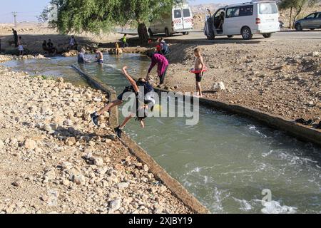 Valle del Giordano, Palestina. 17 luglio 2024. I palestinesi nuotano nel fiume Uja durante i periodi caldi vicino alla città di Gerico, nella valle del Giordano settentrionale. (Foto di Nasser Ishtayeh/SOPA Images/Sipa USA) credito: SIPA USA/Alamy Live News Foto Stock