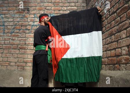 Srinagar, India. 17 luglio 2024. Srinagar, Kashmir, India, il 17 luglio 2024: Un ragazzo kashmiri ha una bandiera palestinese durante la processione Ashura a Srinagar, Kashmir. I musulmani osservano Ashura, che cade il decimo giorno del mese di Muharram, per ricordare il martirio di Imam Hussein, nipote del profeta Maometto, ucciso nella battaglia di Karbala nel 680 d.C. in Iraq. Foto di Danish Showkat/Sipa USA. Crediti: SIPA USA/Alamy Live News Foto Stock