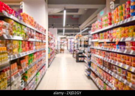 Corridoio del supermercato con scaffali colorati e negozi. Sfocatura astratta come sfondo. Foto Stock