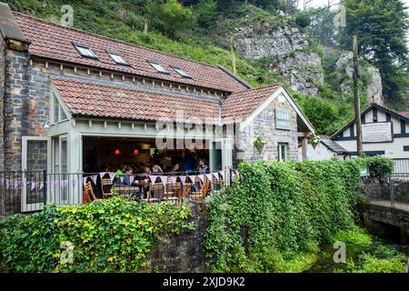 Cafe Gorge Tea Rooms nel villaggio di Cheddar, Mendip Hills, Somerset, con persone che gusteranno tè pomeridiano e spuntini, Inghilterra, Regno Unito Foto Stock