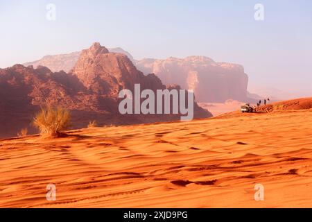 Giordania, Wadi Rum - 2 novembre 2022: Jeep safari nel deserto. Turisti e fuoristrada percorrono le dune di sabbia e il bellissimo paesaggio roccioso Foto Stock