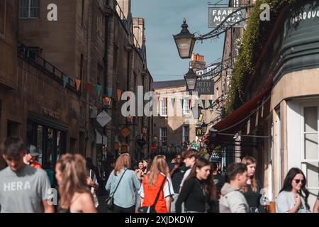 Cambridge, Regno Unito - 8 ottobre 2023: Una strada trafficata a Cambridge, Regno Unito, fiancheggiata da negozi e caffè. La gente cammina lungo la strada acciottolata, con colorate Foto Stock