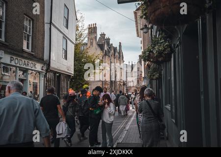 Cambridge, Regno Unito - 8 ottobre 2023: Una strada stretta a Cambridge, Regno Unito, fiancheggiata da edifici storici. La gente passa davanti a un negozio chiamato 'Podarok' verso la t Foto Stock