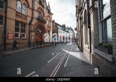 Cambridge, Regno Unito - 8 ottobre 2023 : Una strada stretta a Cambridge, Regno Unito, fiancheggiata da edifici in mattoni. La strada è per lo più vuota, tranne alcuni pedoni Foto Stock