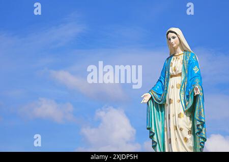 Splendida scultura di Santa Maria, la Santa madre di Dio sullo sfondo del cielo alla luce del sole Foto Stock