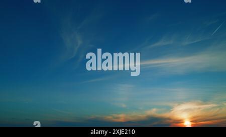 Temporizzato. La compagnia aerea jet vola in alto nel cielo con nuvole che lasciano i contrasti. Tramonto caldo con nuvole ardenti e sfondo contrail di linea aerea. Foto Stock