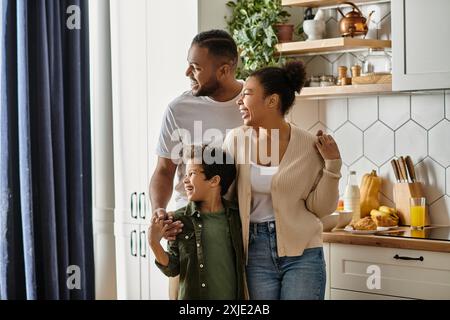 Un uomo, una donna e un bambino condividono un momento di Unione in una cucina accogliente. Foto Stock