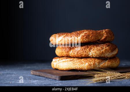 Tradizionale bagel turco / simit con sesamo su tavolo rustico, pasticceria turca per colazione Foto Stock